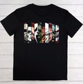 A black short-sleeve t-shirt laid flat on a white wood plank background, featuring a large graphic print of horror movie villains' faces.