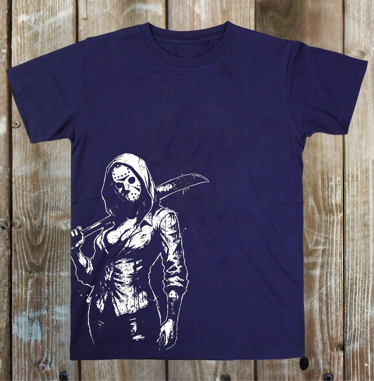 A navy blue short-sleeve t-shirt with a white graphic print of a hooded figure in a hockey mask holding a large machete, displayed flat against a rustic wooden plank background.