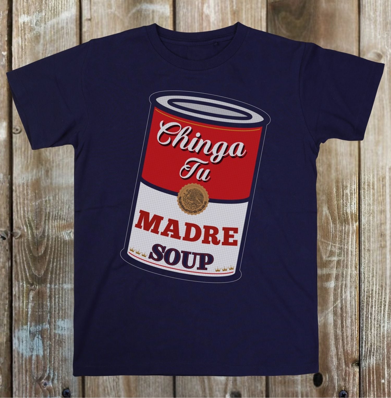 Navy blue t-shirt with a graphic of a red and white soup can labeled 'Chinga Tu Madre Soup' on a wooden background.