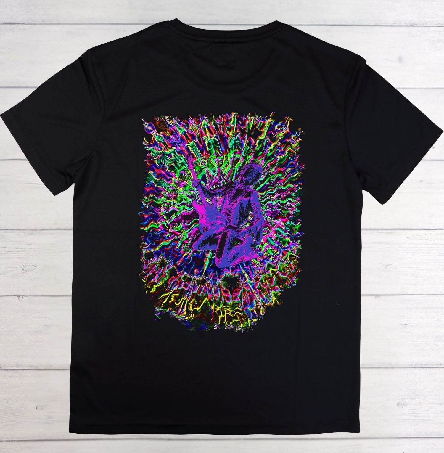Black t-shirt with a colorful graphic design on a wooden surface