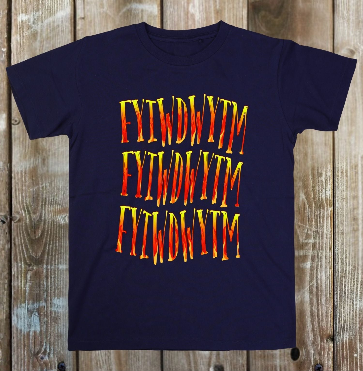 Navy blue t-shirt with 'FYWDWYT' text in red and yellow on a wooden background
