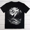 A black short-sleeve t-shirt laid flat on a white wood plank background, featuring a large white graphic print of a wolf howling in a forest by a river under a full moon.