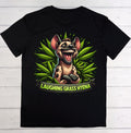 A black short-sleeve t-shirt laid flat on a white wood background, featuring a colorful graphic of a laughing grass hyena surrounded by green leaves, with a banner reading 'LAUGHING GRASS HYENA'.