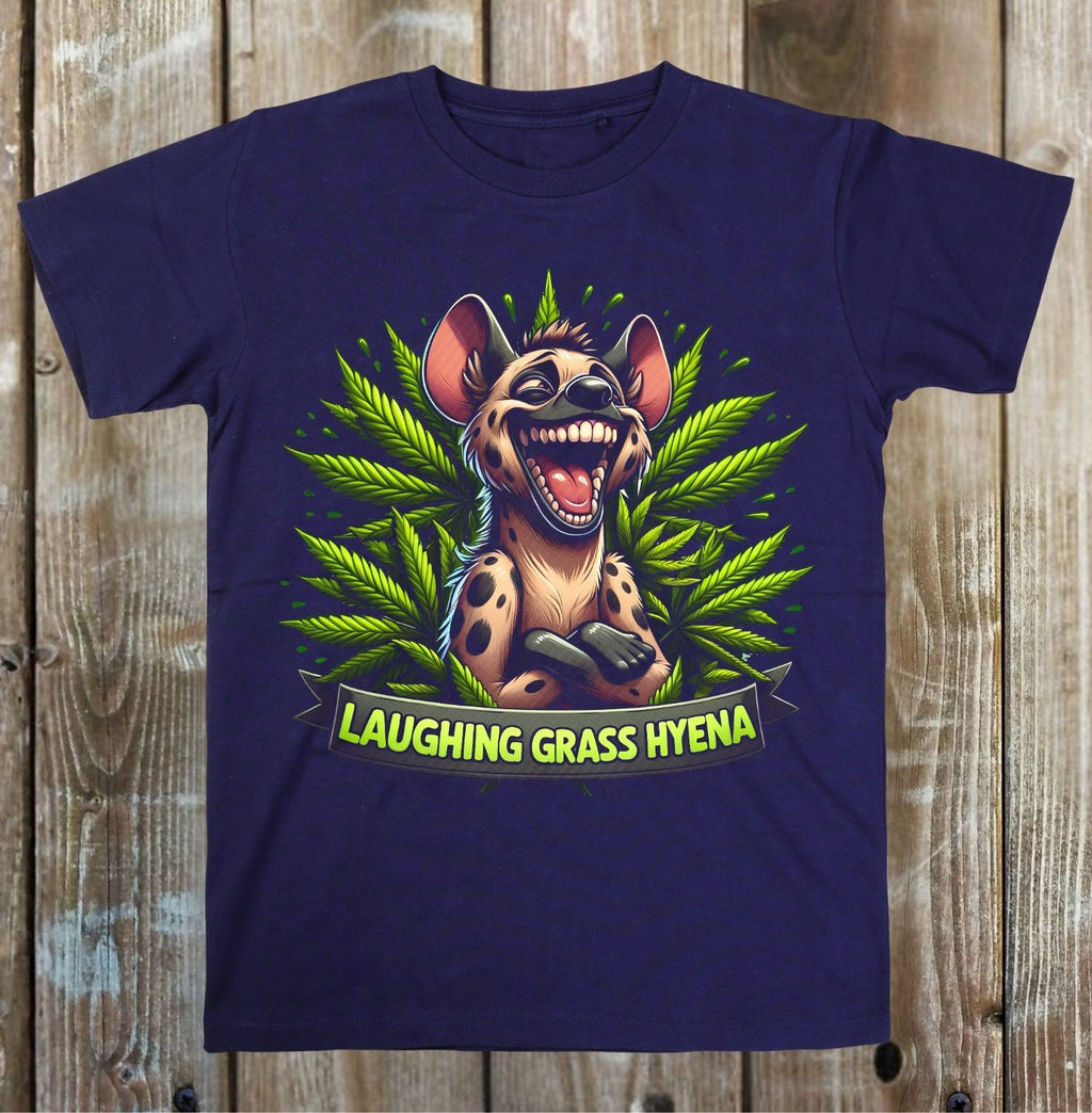 A navy blue short-sleeve t-shirt with a colorful graphic of a laughing grass hyena surrounded by green cannabis leaves, displayed flat against a rustic wooden plank background.