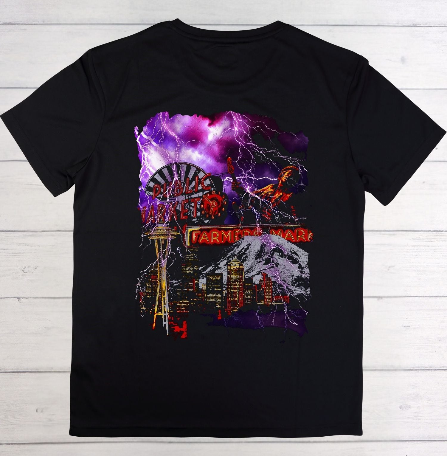 Black t-shirt with a colorful graphic design on a wooden surface