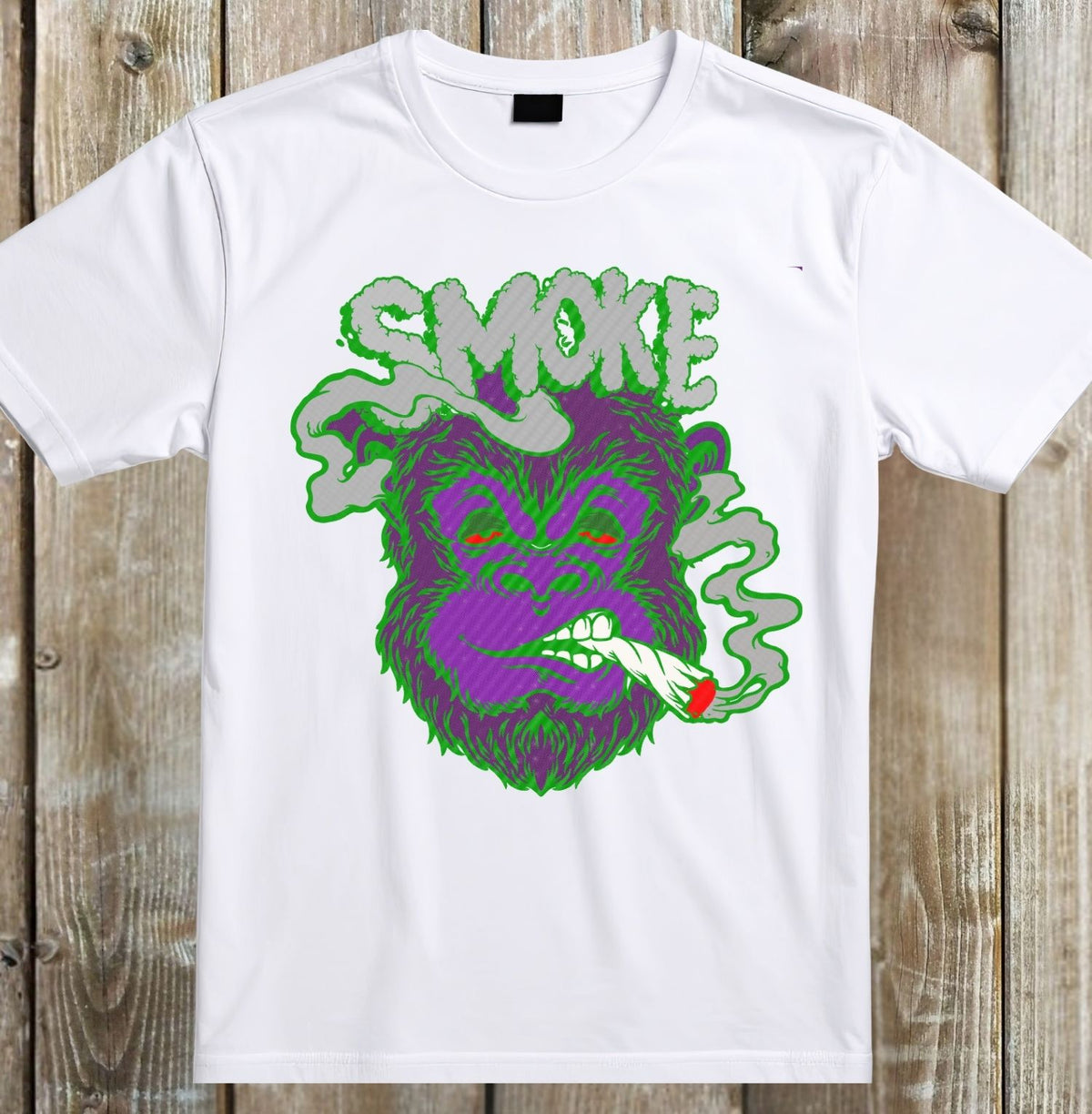 A white short-sleeve crewneck t-shirt laid flat on a rustic wooden plank background, featuring a colorful graphic of a purple furry monster smoking with green smoke and the word 'SMOKE' in green.