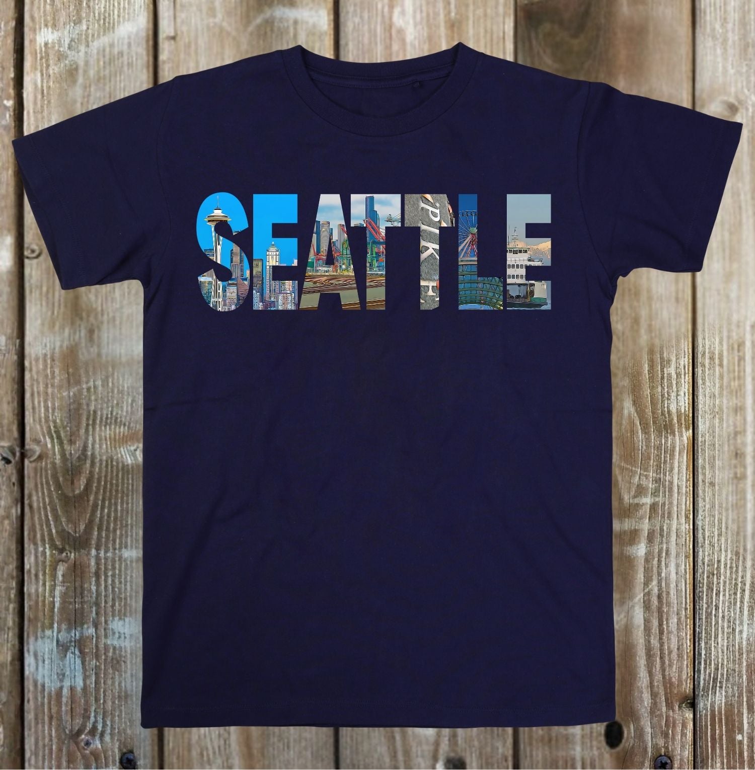 Navy blue t-shirt with 'SEATTLE' printed in colorful letters on a wooden surface