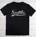 Black t-shirt with 'Seattle' printed on it against a white wooden background