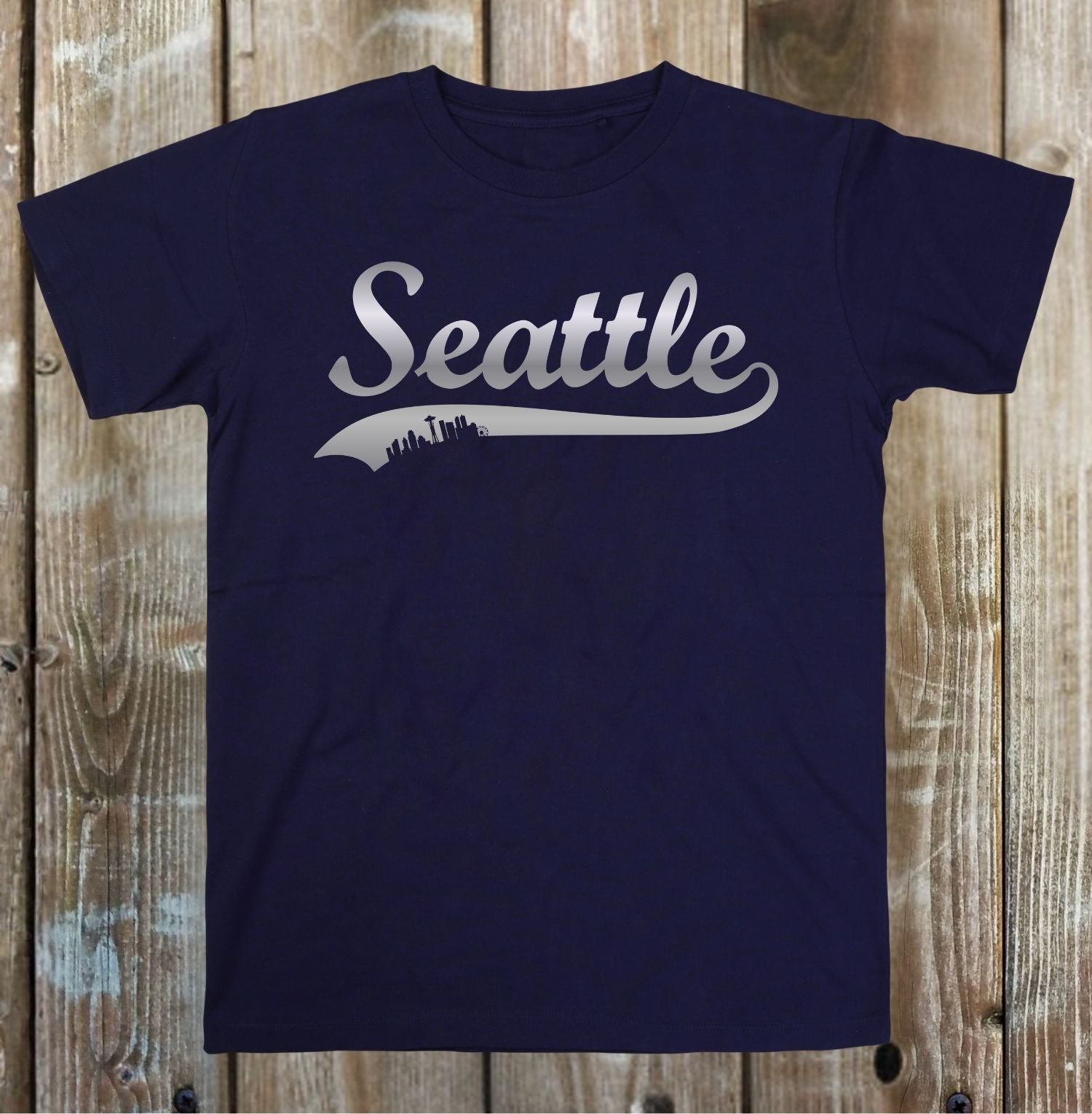 Navy blue t-shirt with 'Seattle' printed on it against a wooden background