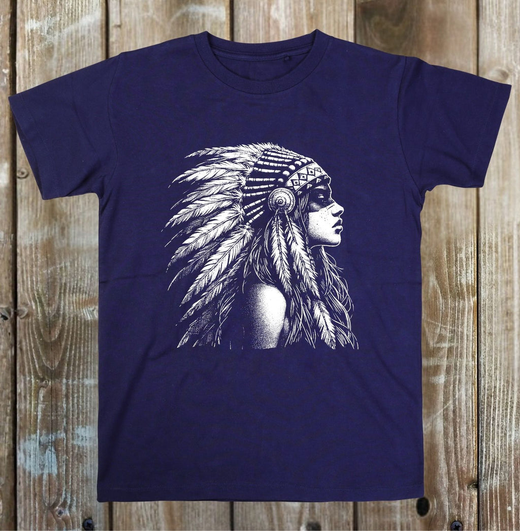 A navy blue short-sleeve t-shirt with a detailed white graphic of a woman in profile wearing a feathered headdress, displayed flat against a rustic wooden plank background.