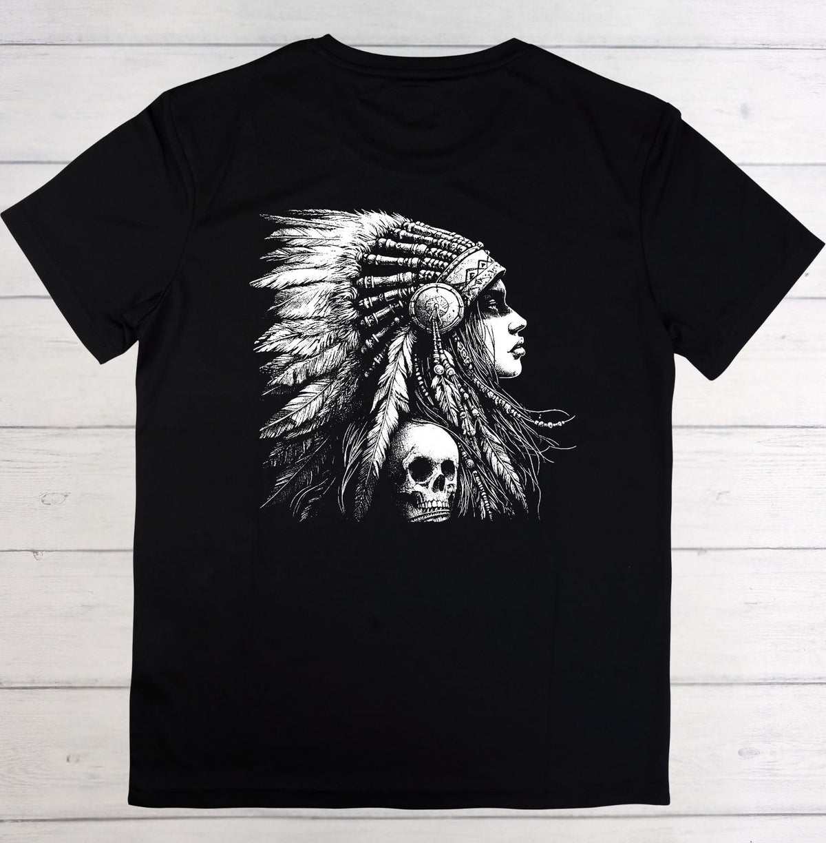A black short-sleeve crewneck t-shirt featuring a large white graphic print of a woman in profile wearing a feathered headdress, laid flat on a light-colored wooden plank background.