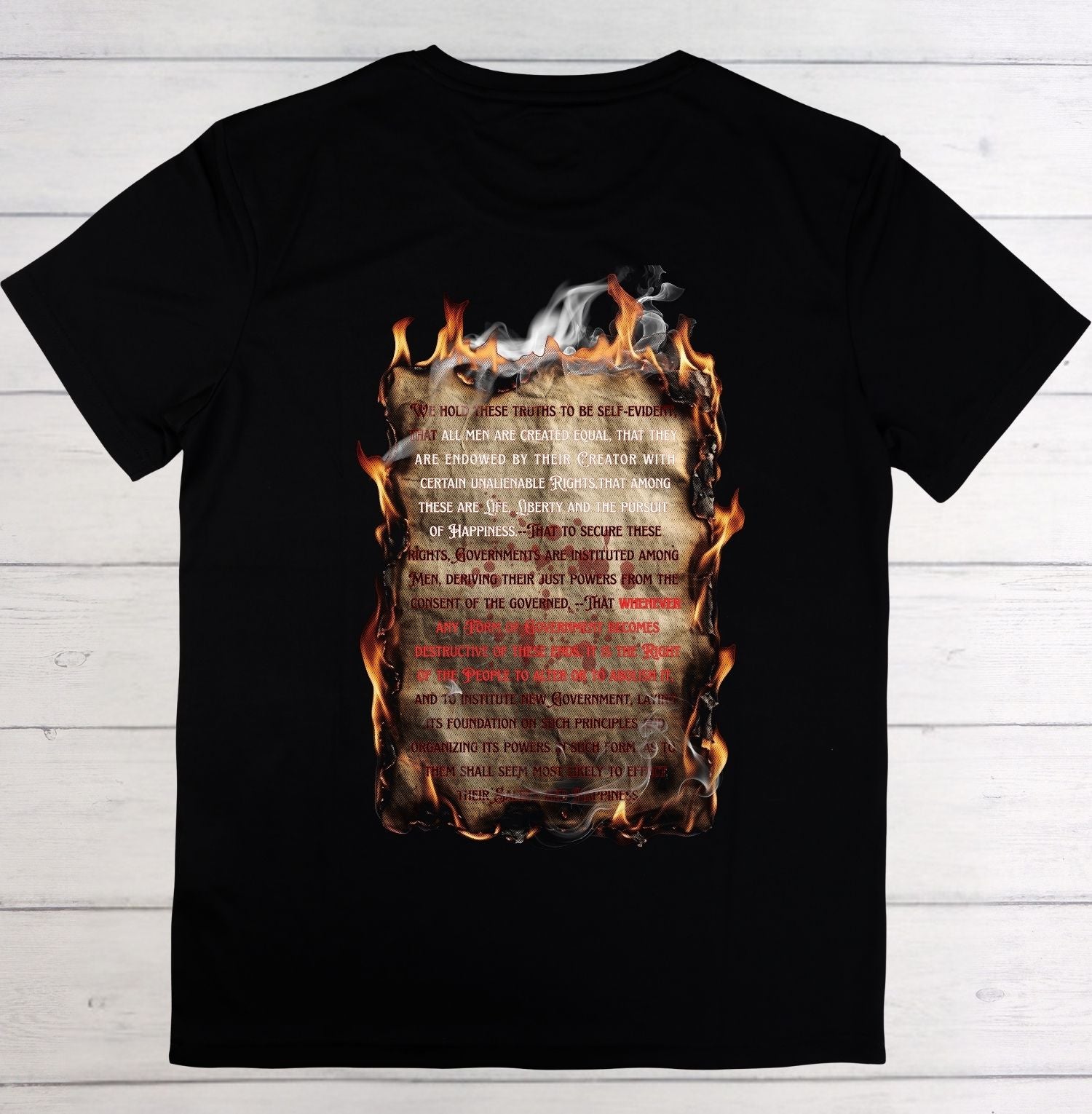 Black t-shirt with a design of a burning document on a wooden surface