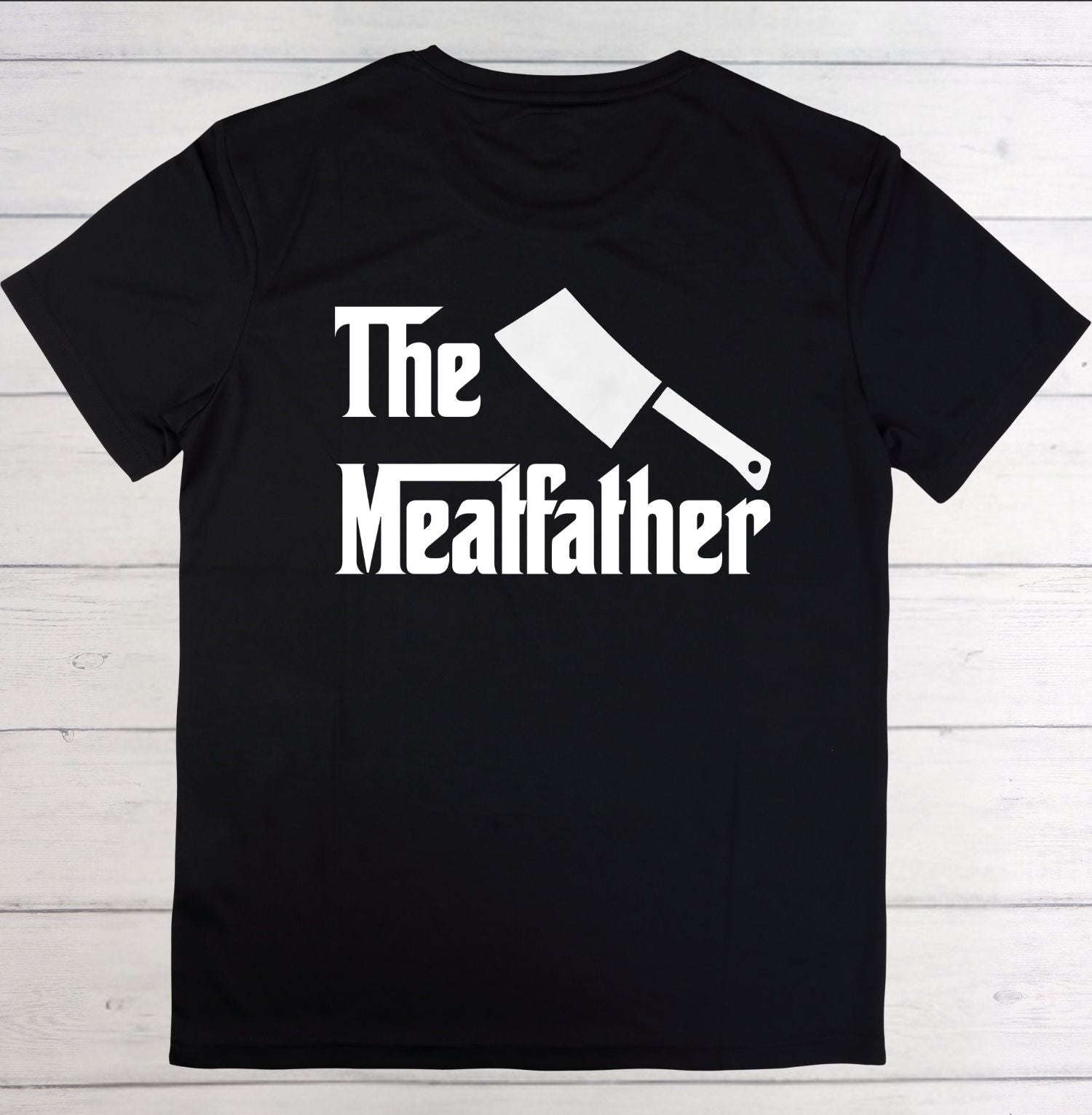 Black t-shirt with 'The Meaffather' graphic on a wooden surface