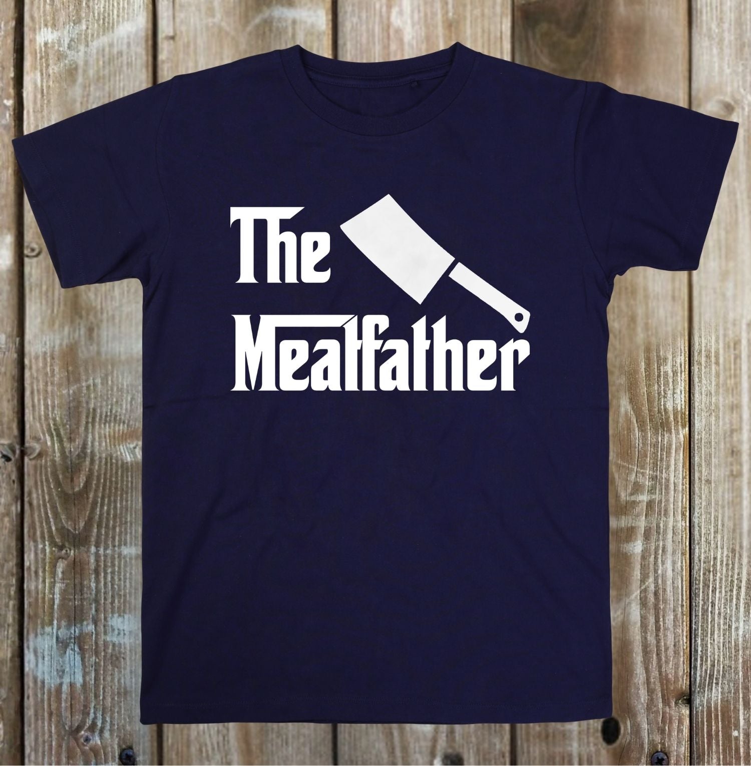 Navy blue t-shirt with 'The Mealfather' graphic on a wooden background