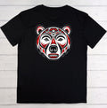 A black short-sleeve t-shirt laid flat on a white wood plank background, featuring a stylized red, white, and black bear head graphic on the chest.