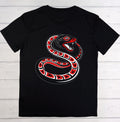 A black short-sleeve crewneck t-shirt featuring a large graphic of a coiled red, black, and white snake on the front, laid flat on a white wood plank background.