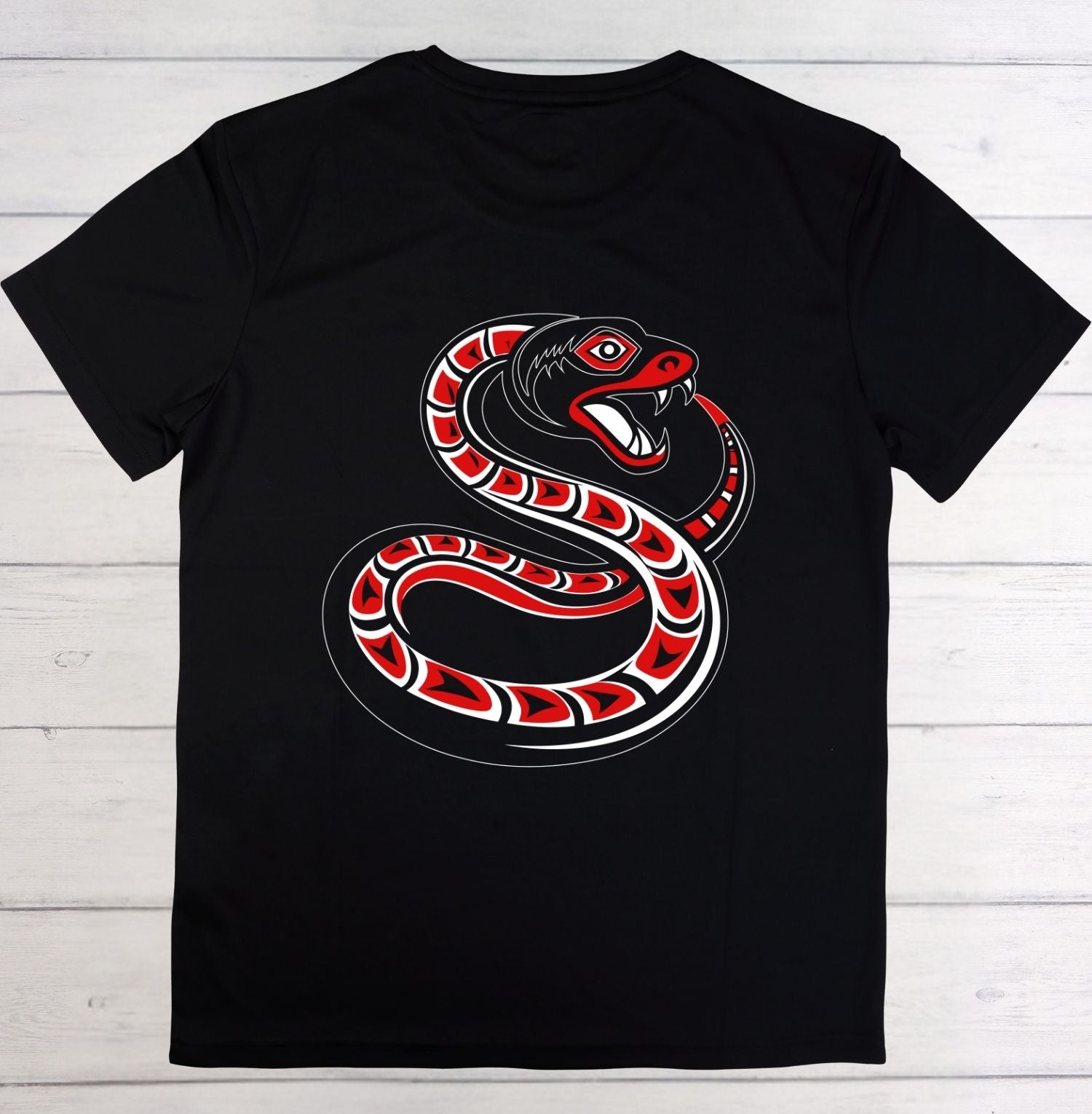 A black short-sleeve crewneck t-shirt featuring a large graphic of a coiled red, black, and white snake on the front, laid flat on a white wood plank background.