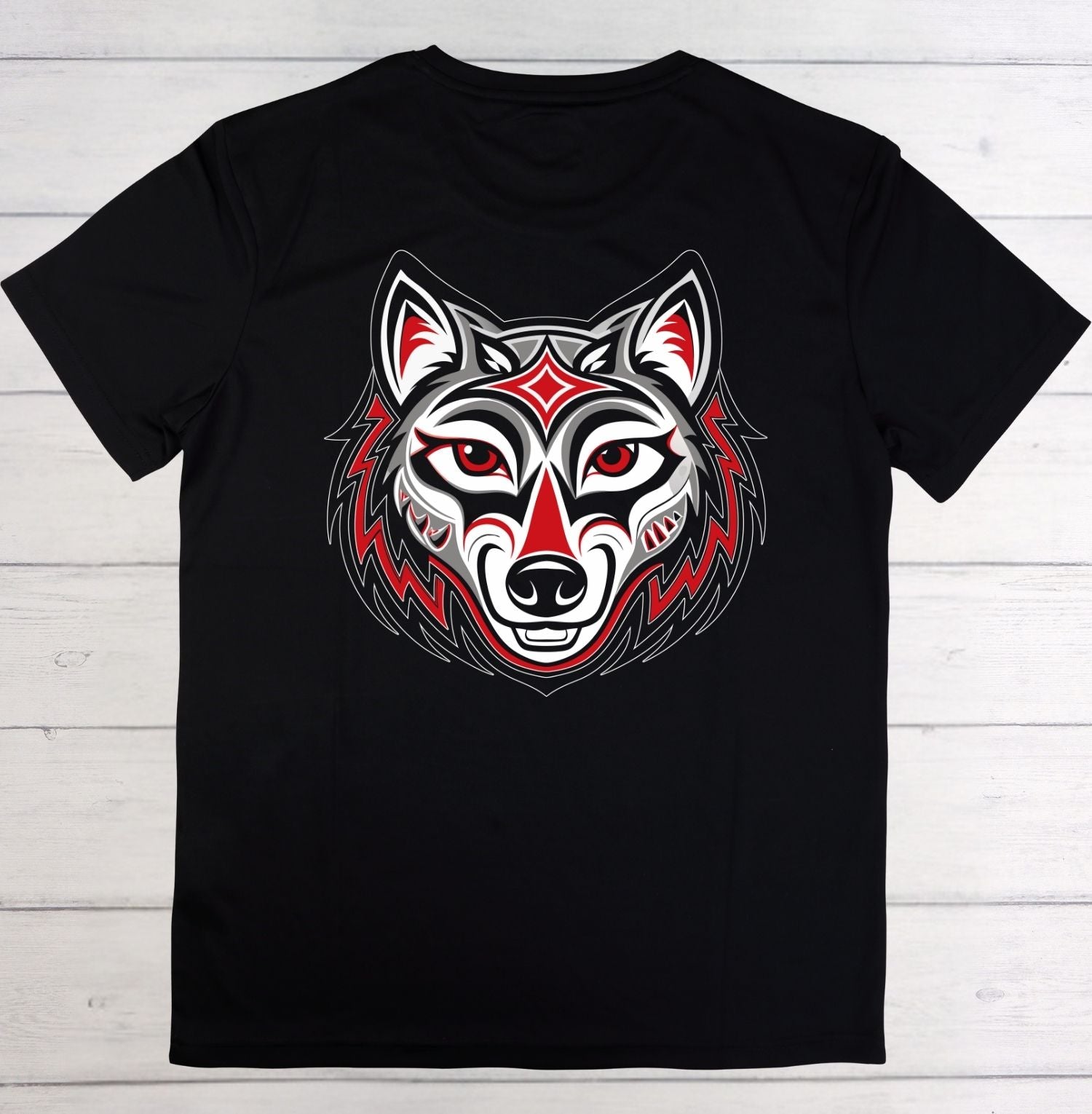 A black short-sleeve crewneck t-shirt featuring a stylized red, white, and black wolf head graphic on the chest, laid flat on a white wood plank background.