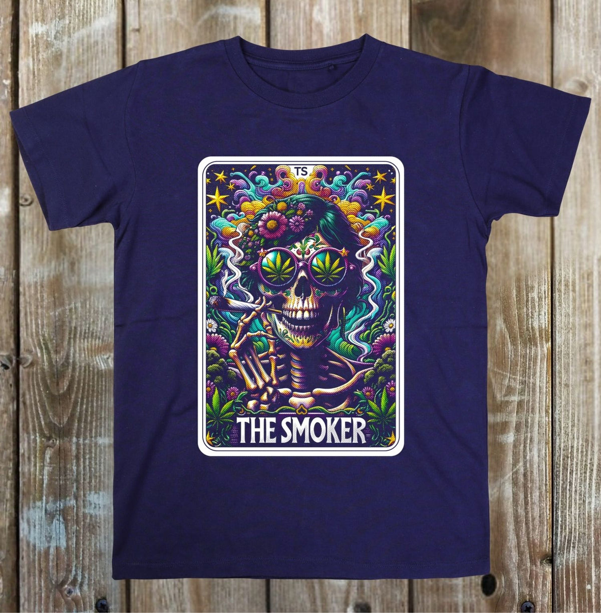 A navy blue short-sleeve t-shirt with a colorful graphic print on the front. The graphic depicts a Day of the Dead style skeleton wearing green bong glasses and smoking, surrounded by flowers and the text 'THE SMOKER' at the bottom.