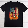 Black t-shirt with American flag graphic and text on a wooden surface