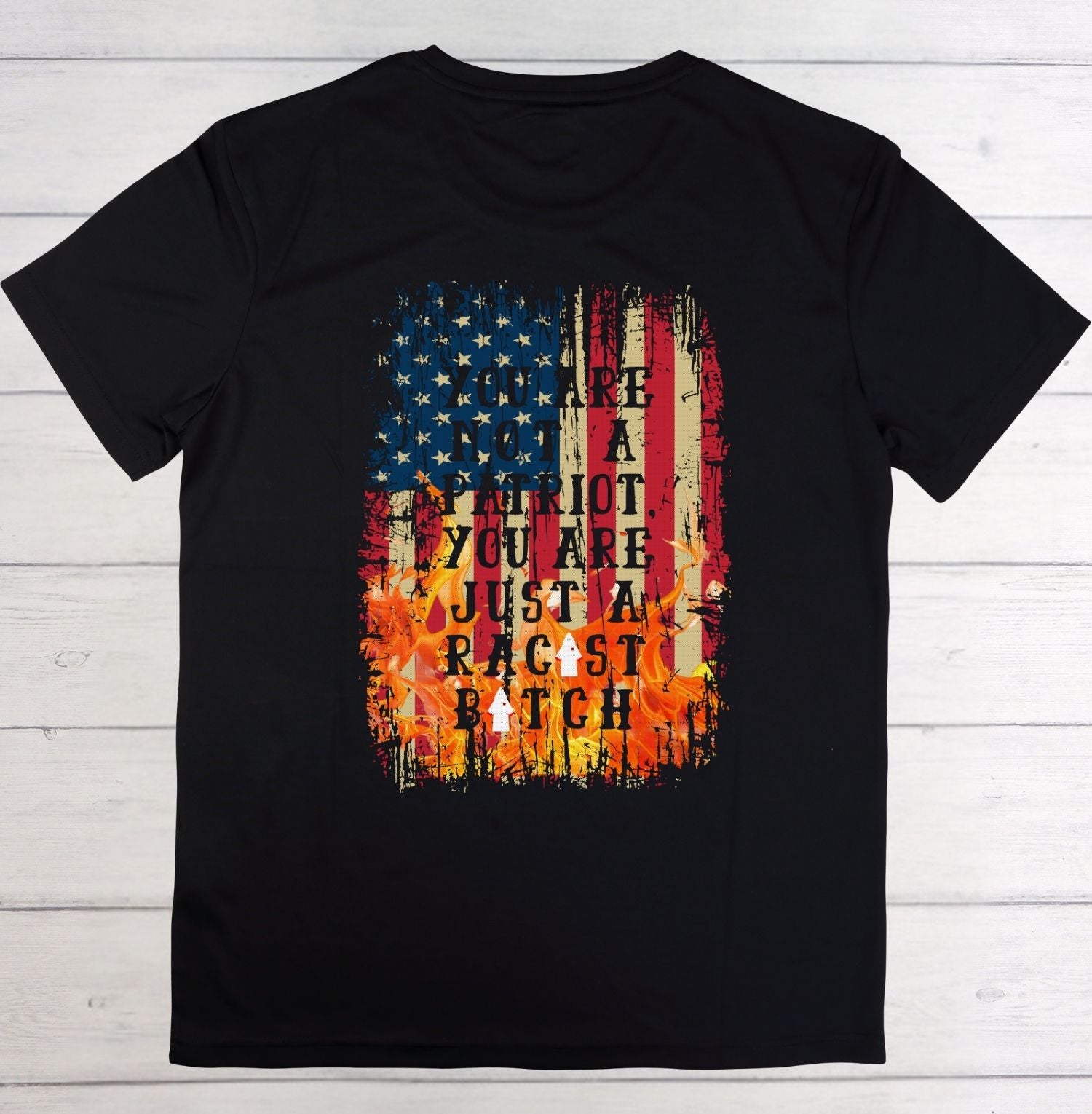 Black t-shirt with American flag graphic and text on a wooden surface