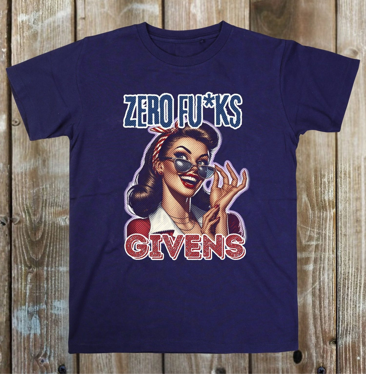 A navy blue graphic t-shirt featuring a retro-style illustration of a woman wearing sunglasses, with the text 'ZERO FU*KS' above and 'GIVENS' below, displayed flat against a rustic wooden plank background.